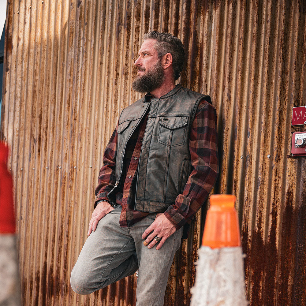 Crafted from buffalo leather, it features two outside chest pockets, two outside hand warmer pockets, two inside concealed carry pockets, antique brass hardware, a quick access gun pocket