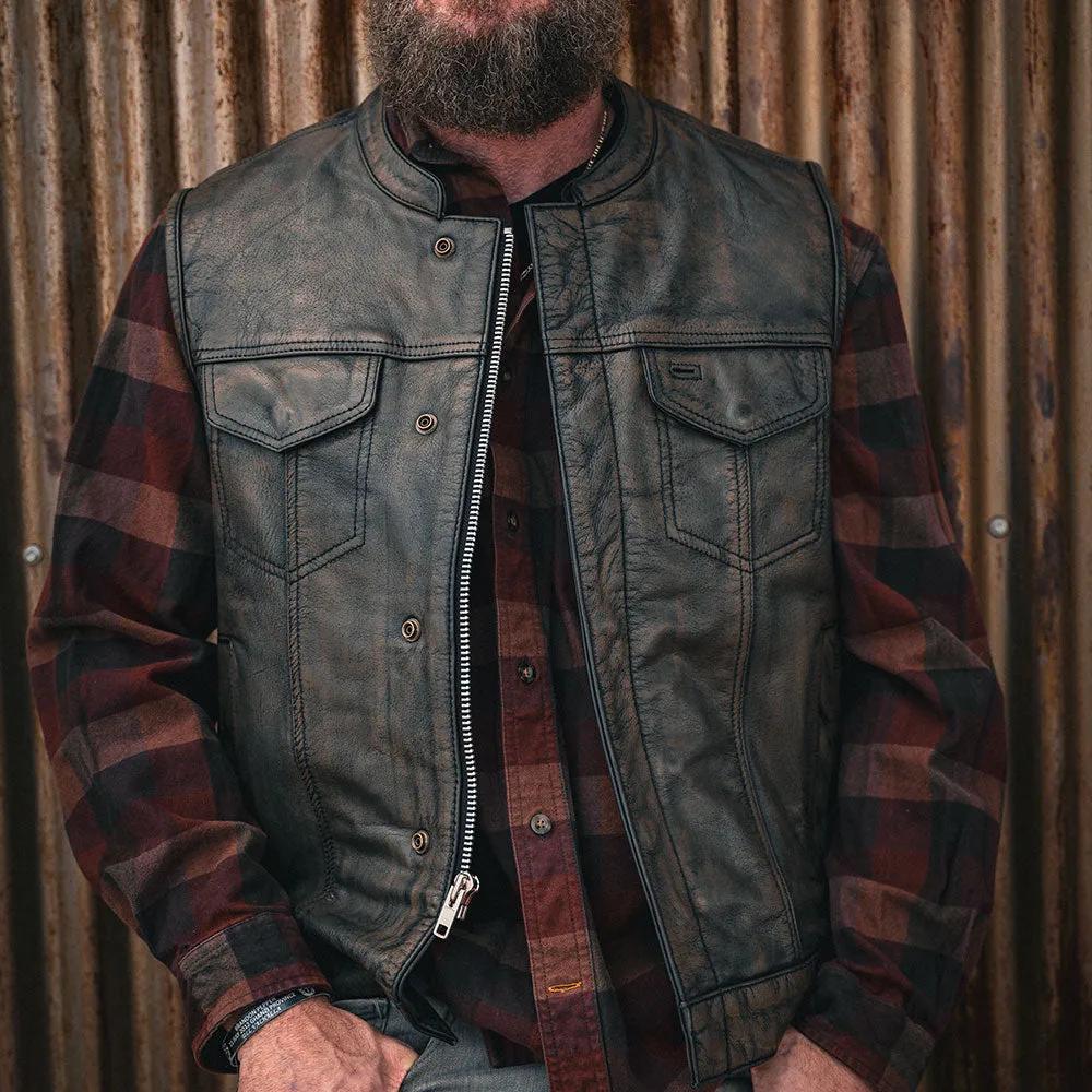 Crafted from buffalo leather, it features two outside chest pockets, two outside hand warmer pockets, two inside concealed carry pockets, antique brass hardware, a quick access gun pocket