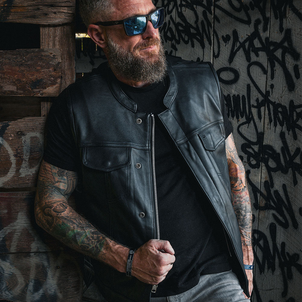 The Men's Ultra SOA Style Club Vest by Unik Ultra blends iconic design with practical features. Made from cowhide leather, it includes four exterior pockets, two inside concealed carry pockets, a zip snap main closure, antique brass hardware