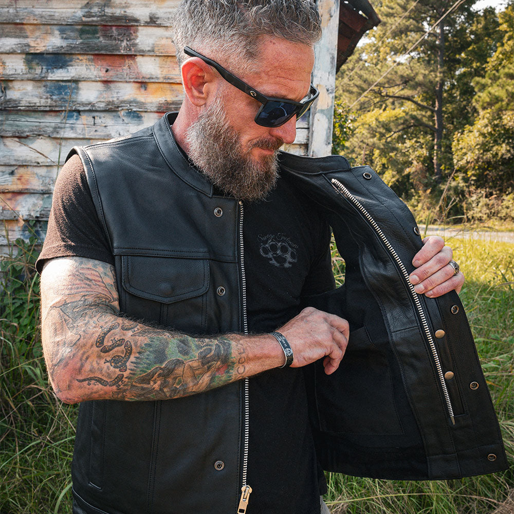 The Men's Ultra SOA Style Club Vest by Unik Ultra blends iconic design with practical features. Made from cowhide leather, it includes four exterior pockets, two inside concealed carry pockets, a zip snap main closure, antique brass hardware