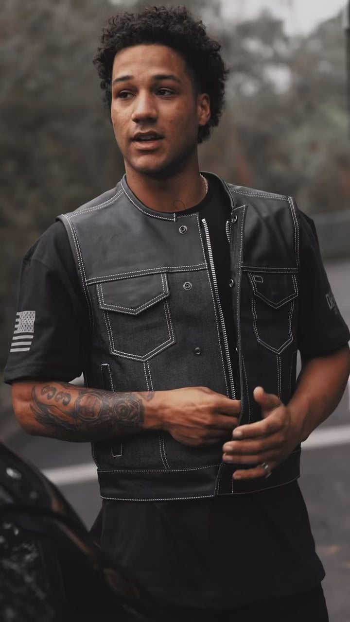 Men’s Lawless club vest featuring a black denim body with leather shoulders and trim, snap front closures, and side lacing for adjustable fit and classic biker style.